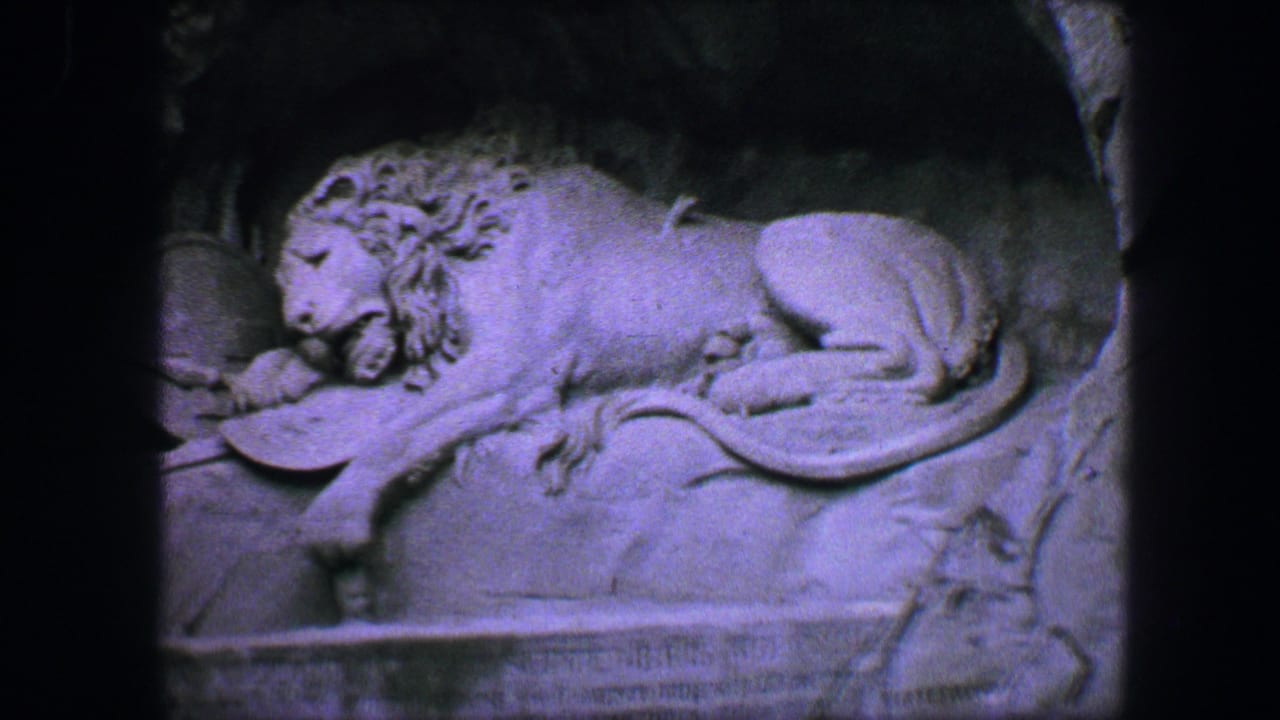 Close view of the reclining lion carved into the stone wall.