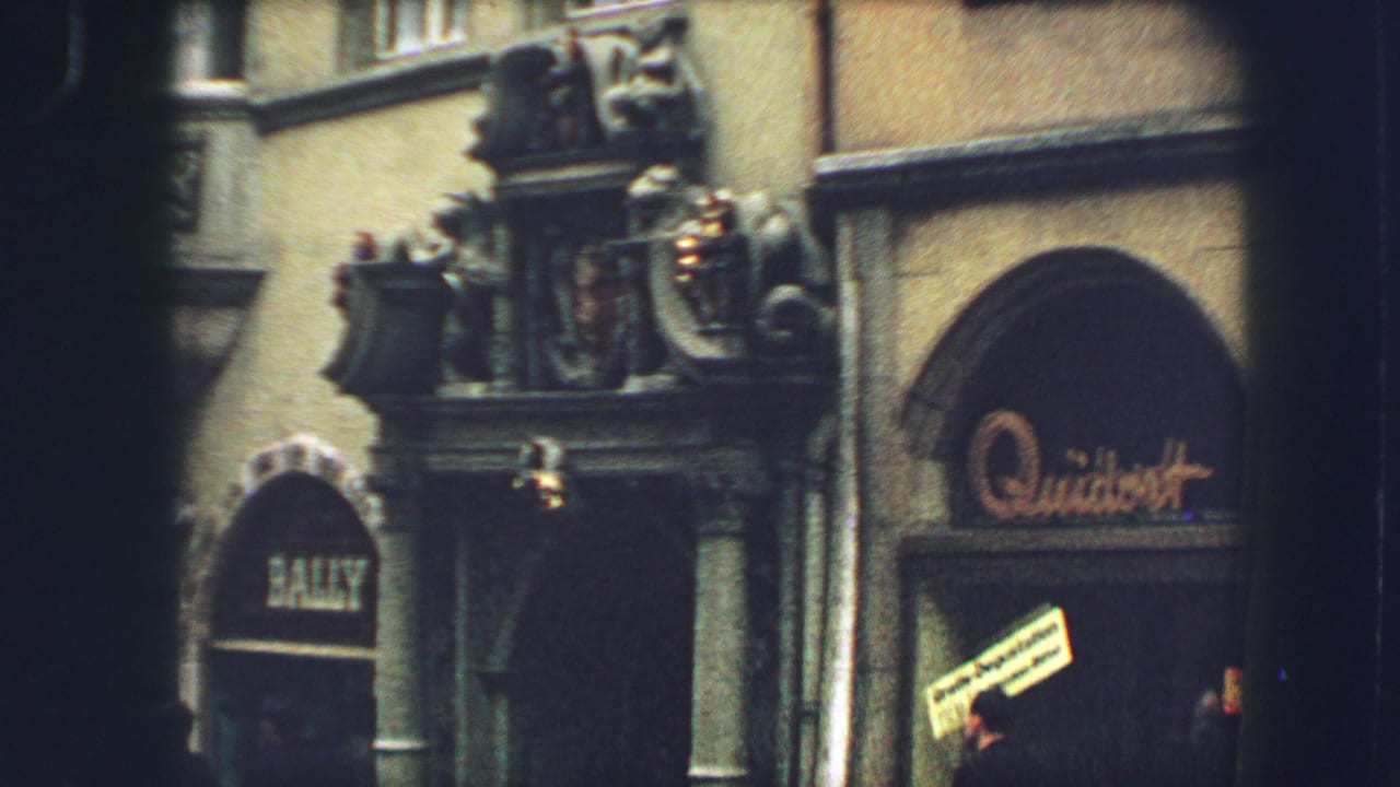 Closer view of decorated doorway and arched shop windows with signage.