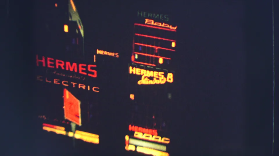 1963 Zurich nighttime 8mm frame showing red-orange Hermes Electric and Hermes Baby signage against dark building facades.