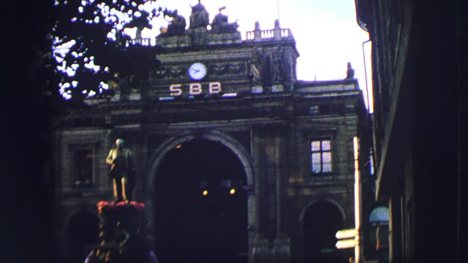 1963 Zurich view of a grand arched stone facade with a clock, SBB lettering, and a statue on a pedestal in front.