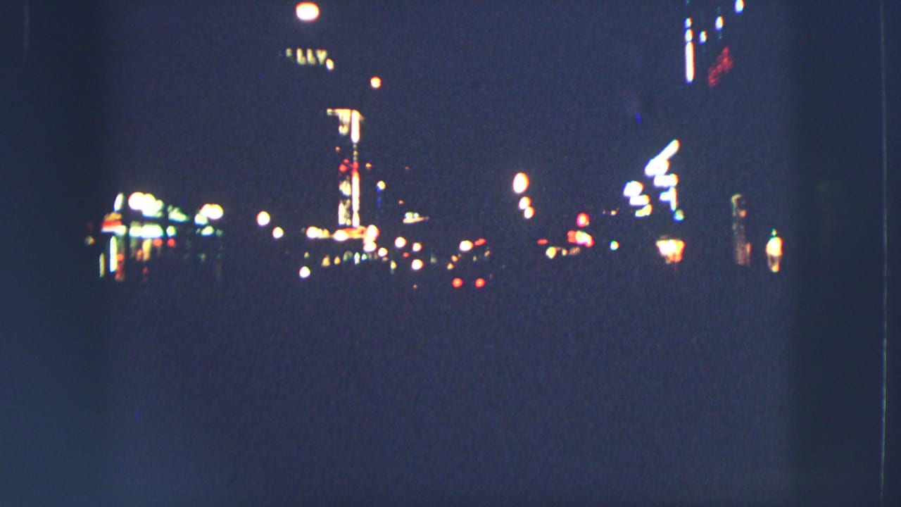 Dark Zurich street at night with scattered neon and street lights.