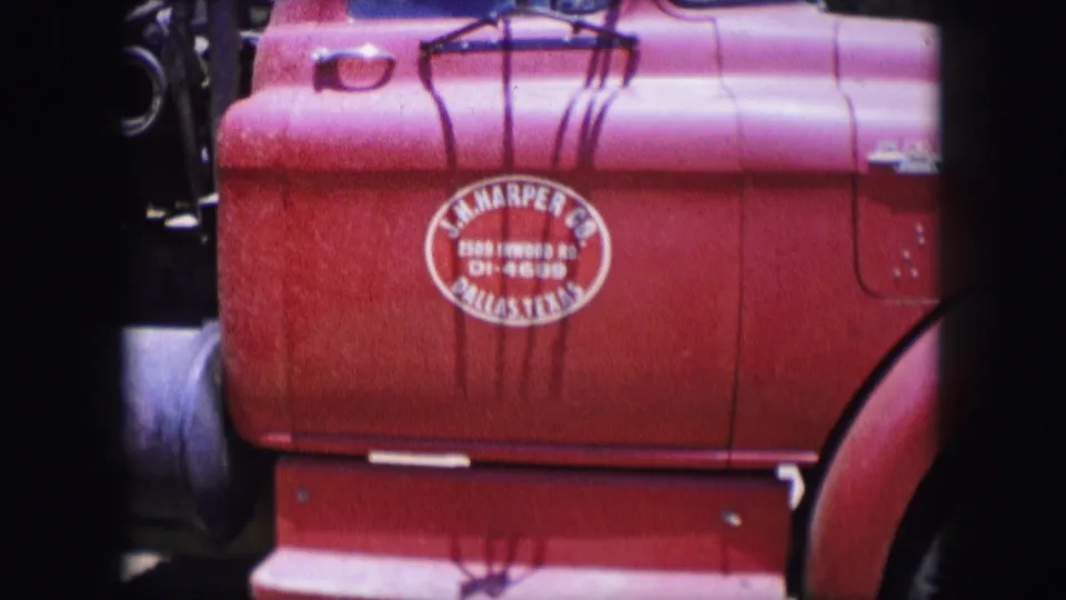 1964 Dallas 8mm frame showing a red truck side panel with oval painted lettering, chain shadows, side tank, and front wheel arch.