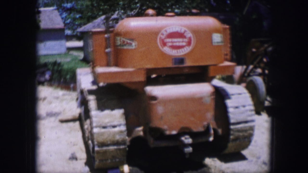 Rear view of an orange crawler tractor with visible logo decals and tracks.
