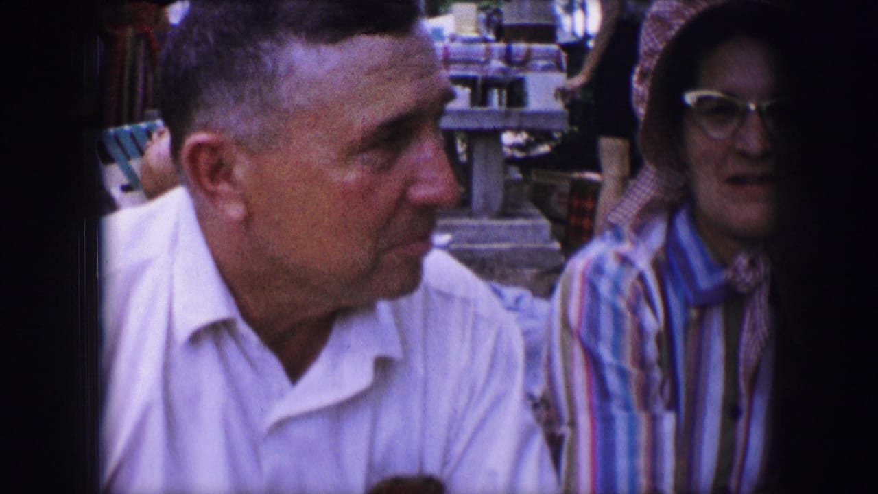 Man in a white shirt turns toward a woman in striped clothing outdoors.