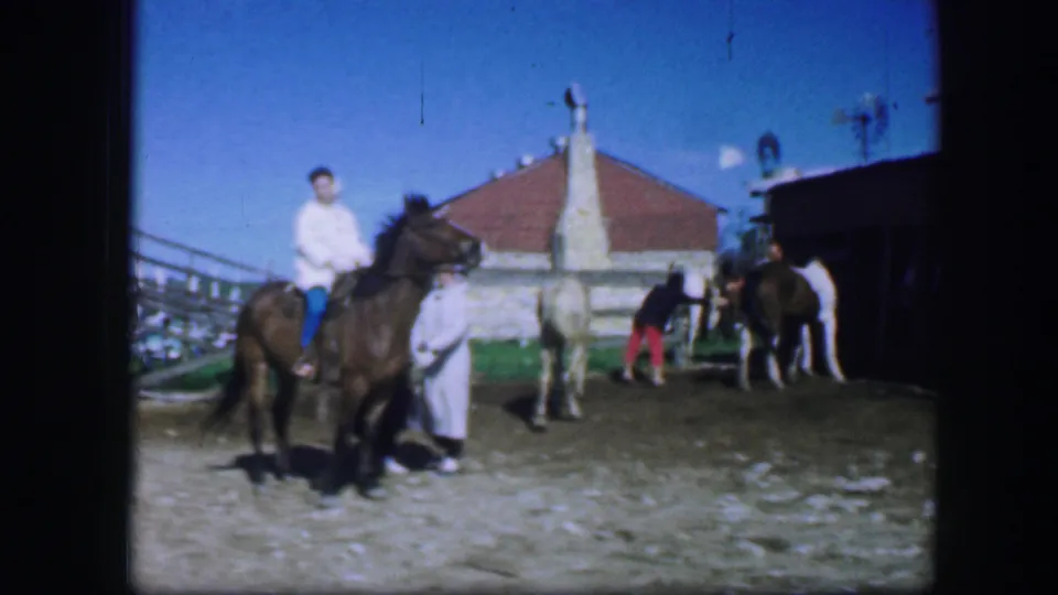 1964 Fort Worth ranch scene showing a mounted rider, several horses, and people gathered in bright sunlight.