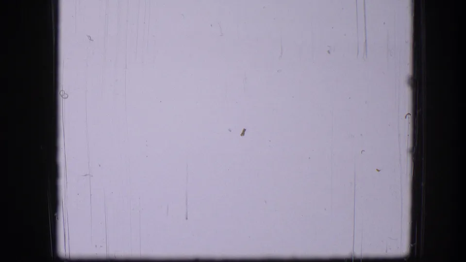 Nearly blank 8mm frame from the 1967 scan, showing pale exposure, dust marks, scratches, and dark gate edges.