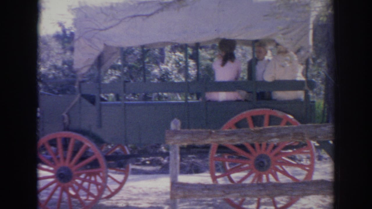 Horse-drawn wagon with red wheels beside a rustic cafe exterior.