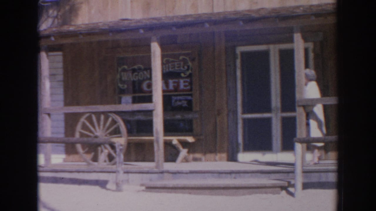 1969 Sarasota frame of the Wagon Wheel Cafe exterior with porch posts, window sign, rail fence, and screen door.