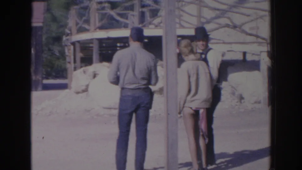 1969 Sarasota-area 8mm frame showing visitors or performers near wooden posts and rustic Western-style structures.