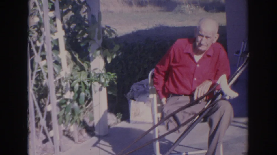 The Sarasota 1969 frame shows an older man seated in bright sun on a patio, with greenery and a lawn behind him.