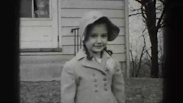 Harrisburg experiment input: a child in a hat outside a house